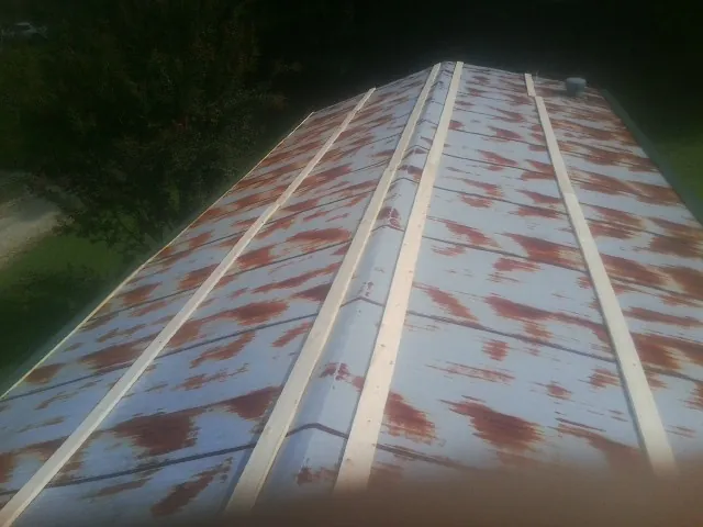 Rusted metal roof panels with new wood purlins before replacement — Storm Damage Roof Repair in Kelford by Roofing Brothers
