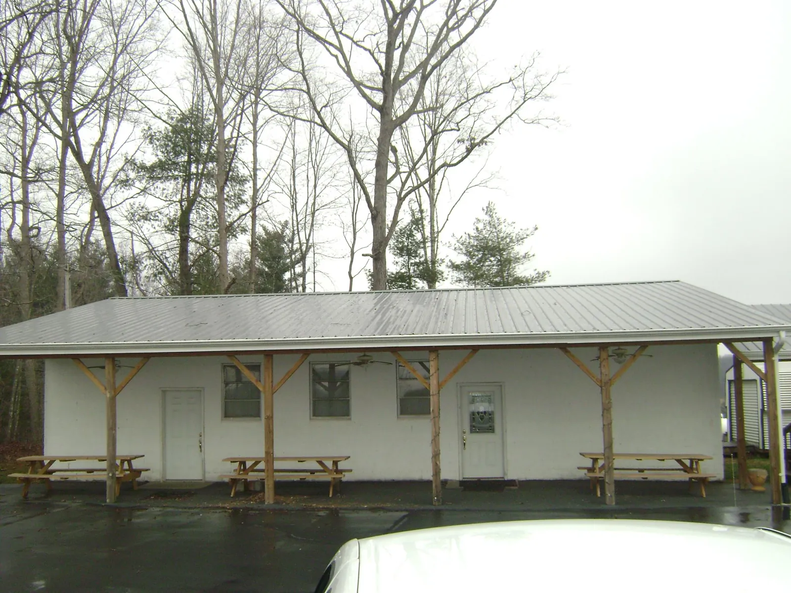 Gray metal roof over a block building with a timber post porch in Kelford